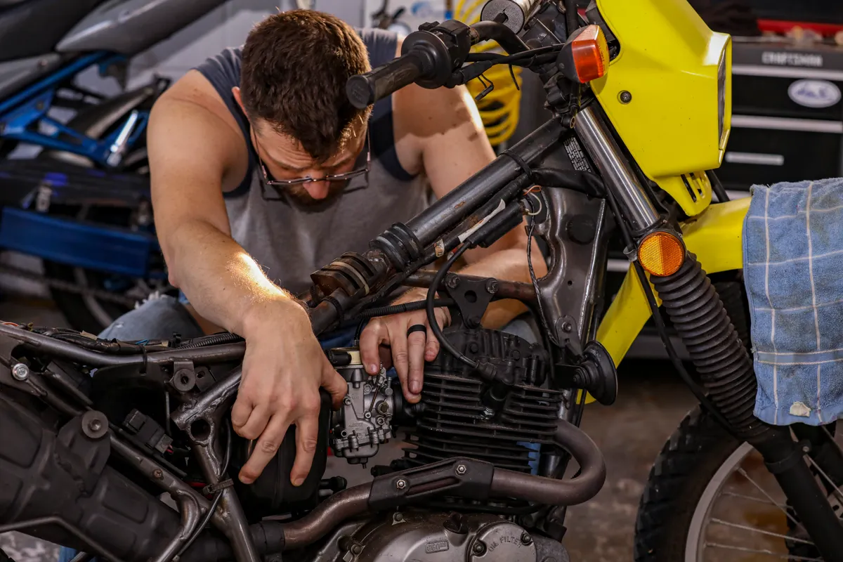Mechanic servicing a motorcycle engine